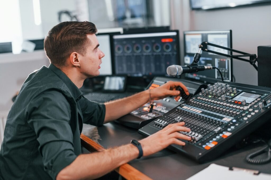 Young man is indoors in the radio studio is busy by broadcast